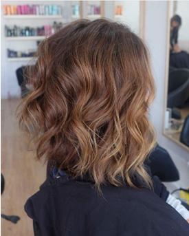 Modelo con cabello castaño y reflejos caramelo.